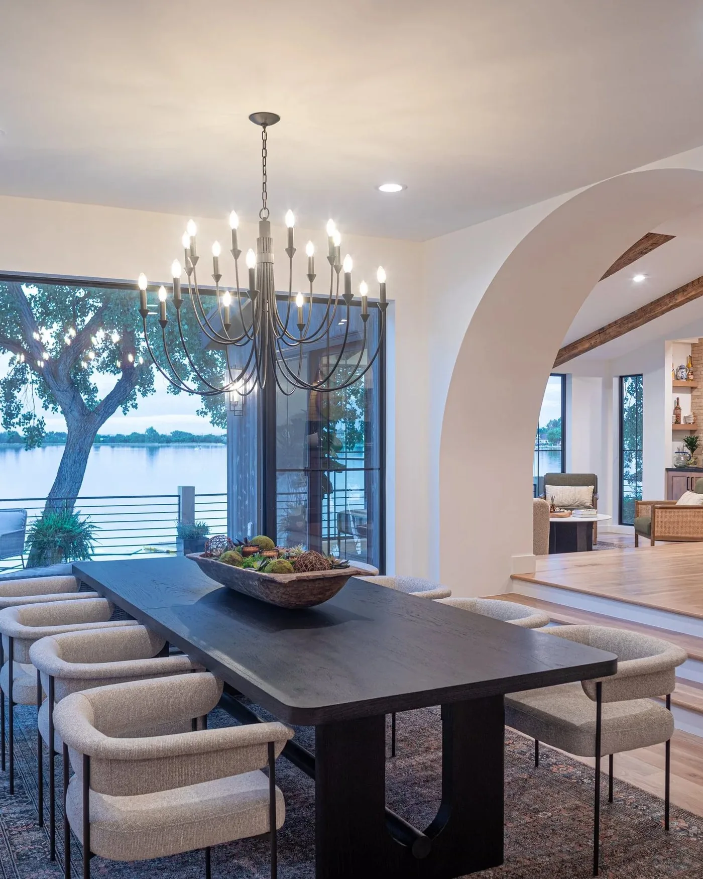 A dining room framed by a plaster arch, looking through to the kitchen beyond