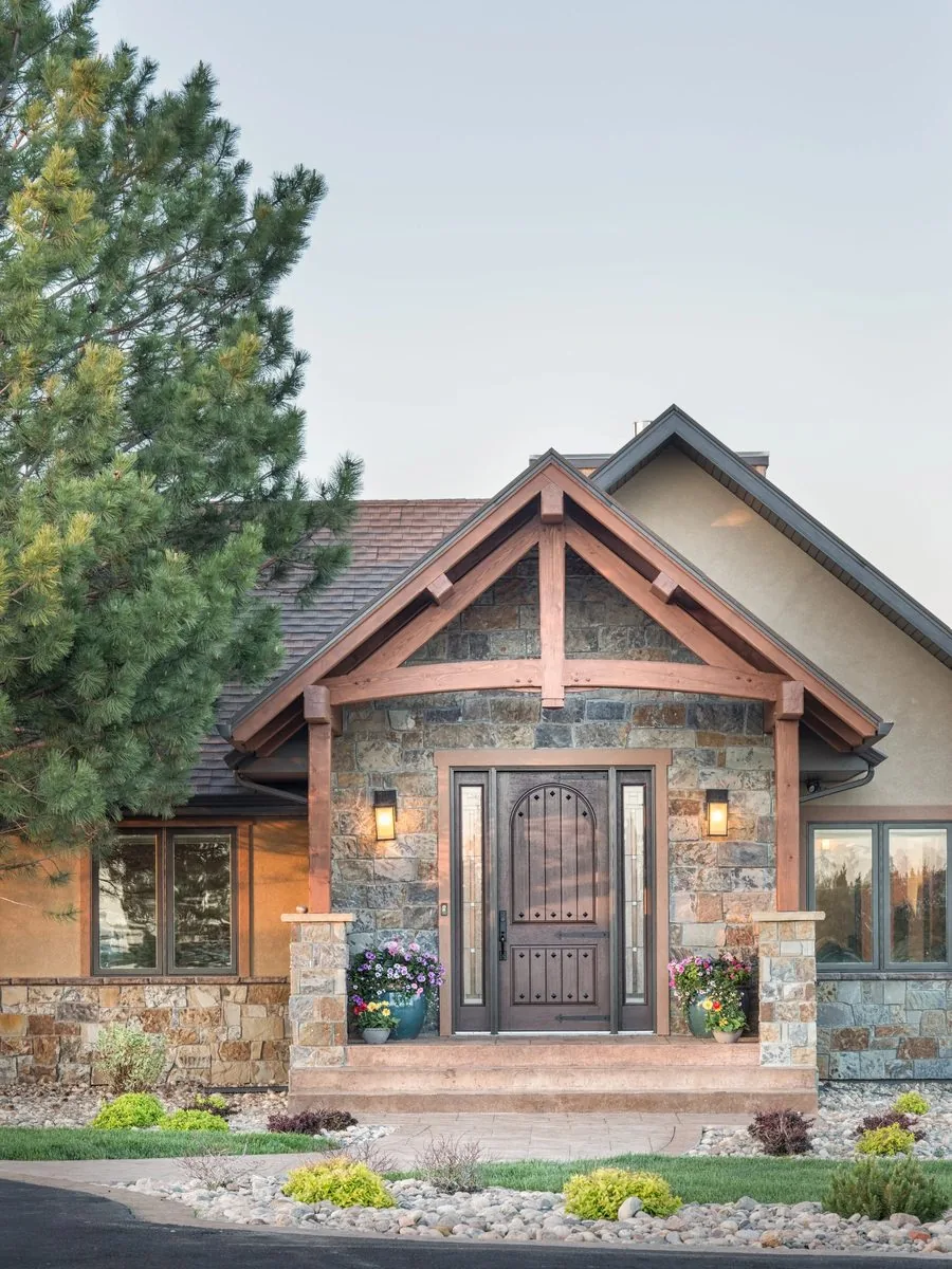 A stone and timber entry portico with a heavy wood front door